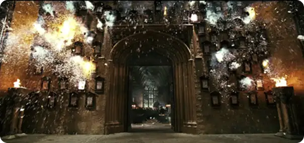 An illuminated archway leads to a spacious, darkened hall filled with flying sparks and magical effects. Flammable materials are visible bursting into light, while walls adorned with multiple photo frames add to the atmosphere, suggesting a place of magic and wonder. The scene evokes a moment of enchantment and activity.