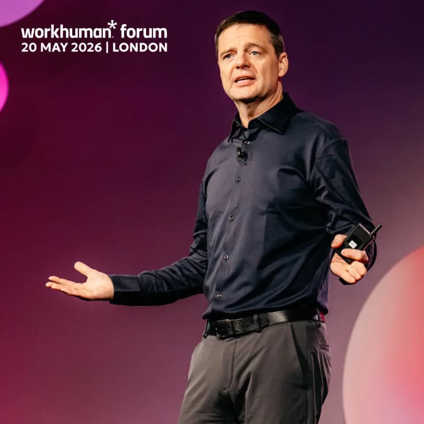 A speaker gesturing with his arms during a presentation at the Workhuman Forum in London, scheduled for May 20, 2026. He is dressed in a dark shirt and pants, holding a small device in one hand. The background features a gradient of colors with the event's logo and date displayed prominently.