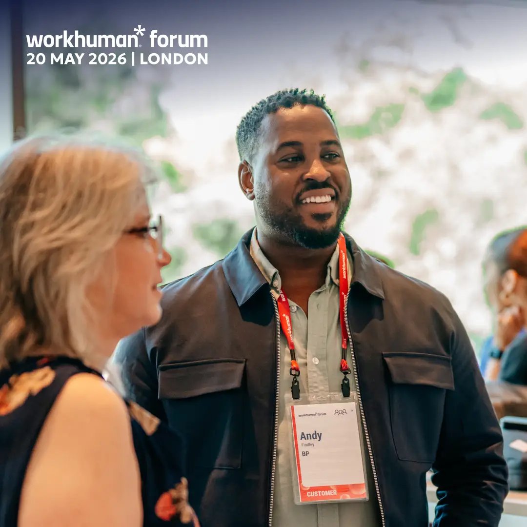 A smiling man named Andy Findley, wearing a dark jacket over a light shirt, interacts with a woman with gray hair and glasses, both engaged in conversation at the Workhuman Forum event. Andy has a name tag indicating his affiliation with BP, and the event details are displayed in the top-left corner with the date and location: "workhuman forum 20 MAY 2026 | LONDON." The background features a blurred setting typical of event venues.